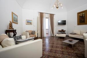 a living room with white furniture and a chandelier at Antica Fortezza Villa Fontana in Valderice