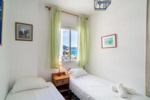 dwa łóżka w pokoju z oknem w obiekcie Pitufo 1D Apartments Casasol w mieście Nerja