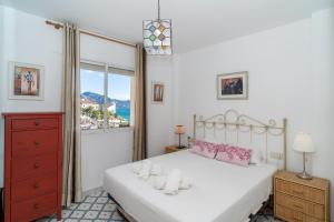 sypialnia z białym łóżkiem i oknem w obiekcie Pitufo 1D Apartments Casasol w mieście Nerja
