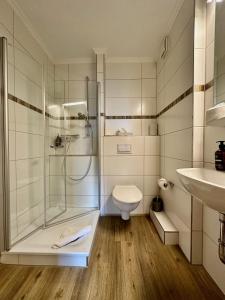 uma casa de banho com um chuveiro, um WC e um lavatório. em Hotel Schultheiss Hameln em Hameln