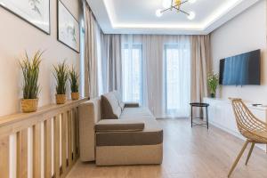 a living room with a couch and a tv at Pomorskie Apartamenty Monte Cassino 27 Deluxe in Sopot