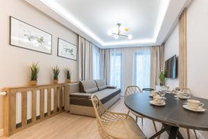 sala de estar con mesa, sillas y sofá en Pomorskie Apartamenty Monte Cassino 27 Deluxe en Sopot