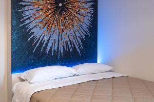 un letto con due cuscini e un dipinto sul muro di V B M apartment a Bari