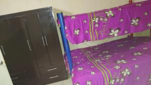 - une chambre avec un lit violet et une commode dans l'établissement pension de fer, à San Luis Potosí
