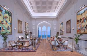 una hall con tavoli e sedie in un edificio di The Chedi Katara Hotel & Resort a Doha