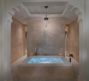 bañera grande en una habitación con techo en The Chedi Katara Hotel & Resort, en Doha