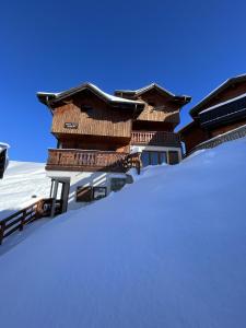 una pila de nieve frente a un edificio en Chalet Topaz - 18 Couchages Sur les Pistes avec Services, en Plagne Villages