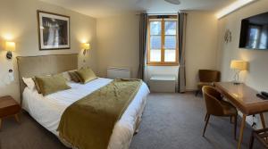 a hotel room with a bed and a desk and a desk at Logis Hôtel des Messageries in Arbois