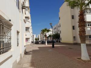 una calle de la ciudad con palmeras y una boca de incendios en appartement NADOR wifi gratuit en Nador