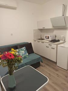 sala de estar con sofá y mesa con flores en סטודיו חדש ויפה עם נוף לים, en Netanya