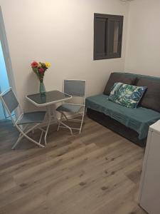 a living room with a couch and a table at סטודיו חדש ויפה עם נוף לים in Netanya