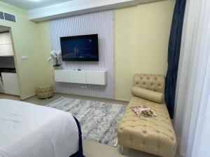 a bedroom with a bed and a television on a wall at Infinity Blue - Studio on Al Marjan Island with a private beach in Ras al Khaimah