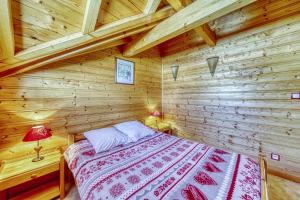sypialnia z łóżkiem w drewnianym domku w obiekcie Chalet l'Hermine w mieście La Toussuire