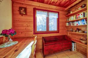 una habitación con un banco rojo en una cabaña de madera en Chalet l'Hermine en La Toussuire