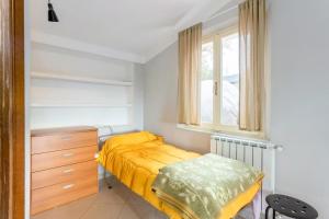 ein Schlafzimmer mit einem Bett, einer Kommode und einem Fenster in der Unterkunft Casetta Indipendente in Castelnuovo Magra