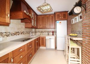 a kitchen with wooden cabinets and a white refrigerator at Casa Nayroa by Spainsunrentals 1019 in Nerja