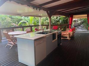 a kitchen on a deck with a table and chairs at Le Domaine du Rocher Noir in Pointe-Noire