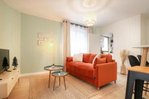 - un salon avec un canapé orange et une table dans l'établissement Le Cocon des Jacobins - Rennes Centre, à Rennes