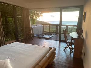 a bedroom with a bed and a view of the ocean at Le Domaine du Rocher Noir in Pointe-Noire