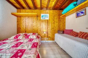 a bedroom with a bed and a couch in a room at Chalet les Colchiques in La Toussuire