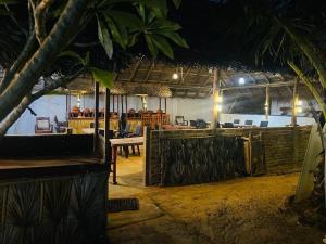 un ristorante con tavolo e sedie di notte di Resort Maya Beach a Trincomalee