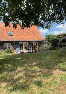 une maison avec une table et des chaises dans la cour dans l'établissement Cottage chaleureux au cœur des Monts de Flandres, à Saint-Jans-Cappel