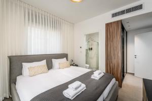 a bedroom with a bed with two towels on it at Luxurious Huge 2BDR&2Bth w Parking- mahne yehuda sea-u jerusalem in Jerusalem