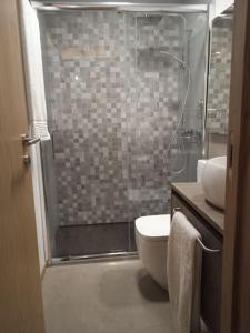 a bathroom with a shower and a toilet and a sink at VillaGarcia-Casa da Peneira in Terras de Bouro +18 photos