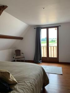1 dormitorio con 1 cama y puerta corredera de cristal en Cottage chaleureux au cœur des Monts de Flandres, en Saint-Jans-Cappel