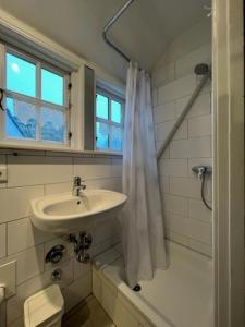 een witte badkamer met een wastafel en een douche bij Reetstübchen in Nieblum