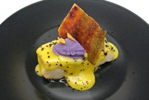 a black plate with a piece of food on it at Catalonia Gran Vía Madrid in Madrid