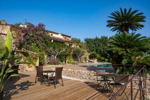 une terrasse avec des tables et des chaises ainsi qu'une piscine dans l'établissement Le Clos de Mansart, à Grimaud