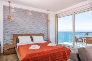 a bedroom with a bed and a view of the ocean at CORFU MARIS BELLOS in Benitses