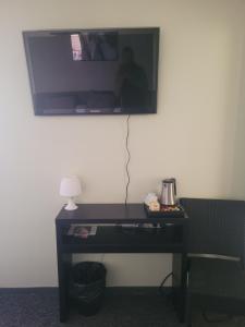 a desk with a television on a wall with a lamp at Hostellerie de Rimplas in Rimplas