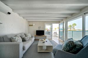 a living room with a couch and a tv at Maspalomas Beach Point in San Bartolomé de Tirajana