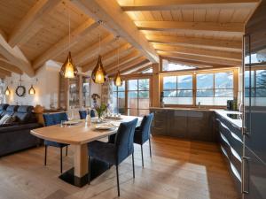 uma cozinha e sala de jantar com mesa e cadeiras em Luxusappartement Alpenliebe em Oberndorf in Tirol