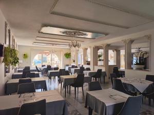 un comedor con mesas y sillas blancas en Hôtel-Restaurant le Commerce, en Nogaro