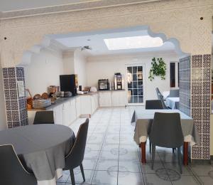 eine Küche und ein Esszimmer mit Tischen und Stühlen in der Unterkunft Hôtel-Restaurant le Commerce in Nogaro