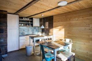 cocina con paredes de madera, mesa y sillas en Kostovac Boutique Homes - House 1 en Kopaonik