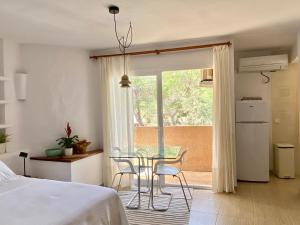 a bedroom with a table and chairs and a window at CALMA Es Pujols in Es Pujols