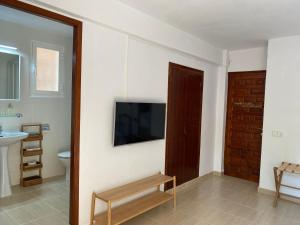 a bathroom with a toilet and a television on a wall at CALMA Es Pujols in Es Pujols