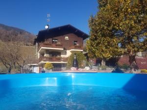 a large swimming pool in front of a house at Casa Margherita Chambres d'Hôtes & SPA in Challand Saint Anselme
