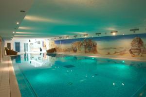 a large swimming pool with a painting on the wall at Tradition Julen Hotel in Zermatt