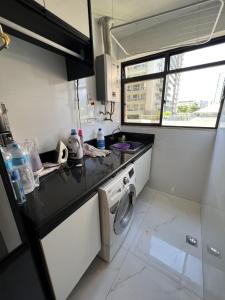 a small kitchen with a washing machine in it at Flat Barra - Liberty Place in Rio de Janeiro
