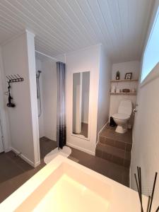 a bathroom with a bath tub and a toilet at Summarhús29 in Tvøroyri