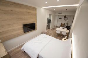 テッサロニキにあるOrnament Suites, Nilie Hospitality MGMTのベッドルーム(白いベッド1台付)、リビングルームが備わります。