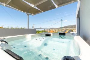 a hot tub on the roof of a house at Casa Alan by Rent2u, Lda in Arco da Calheta