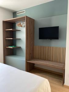een slaapkamer met een bed en een tv aan de muur bij Innesti Rooms&Apartments in Pergine Valsugana