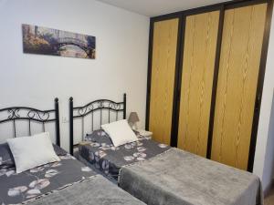 プエルト・デ・サンティアゴにあるApartment Los Gigantesのベッドルーム1室(ベッド2台、木製クローゼット付)