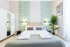 1 dormitorio con 1 cama grande y toallas. en Rome as you feel - Diocleziano Apartment, en Roma